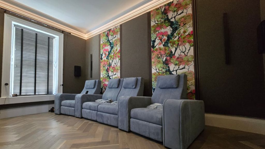 Cotswolds home cinema with cherry-blossom acoustic fabric panels and dark-stained wood panelling