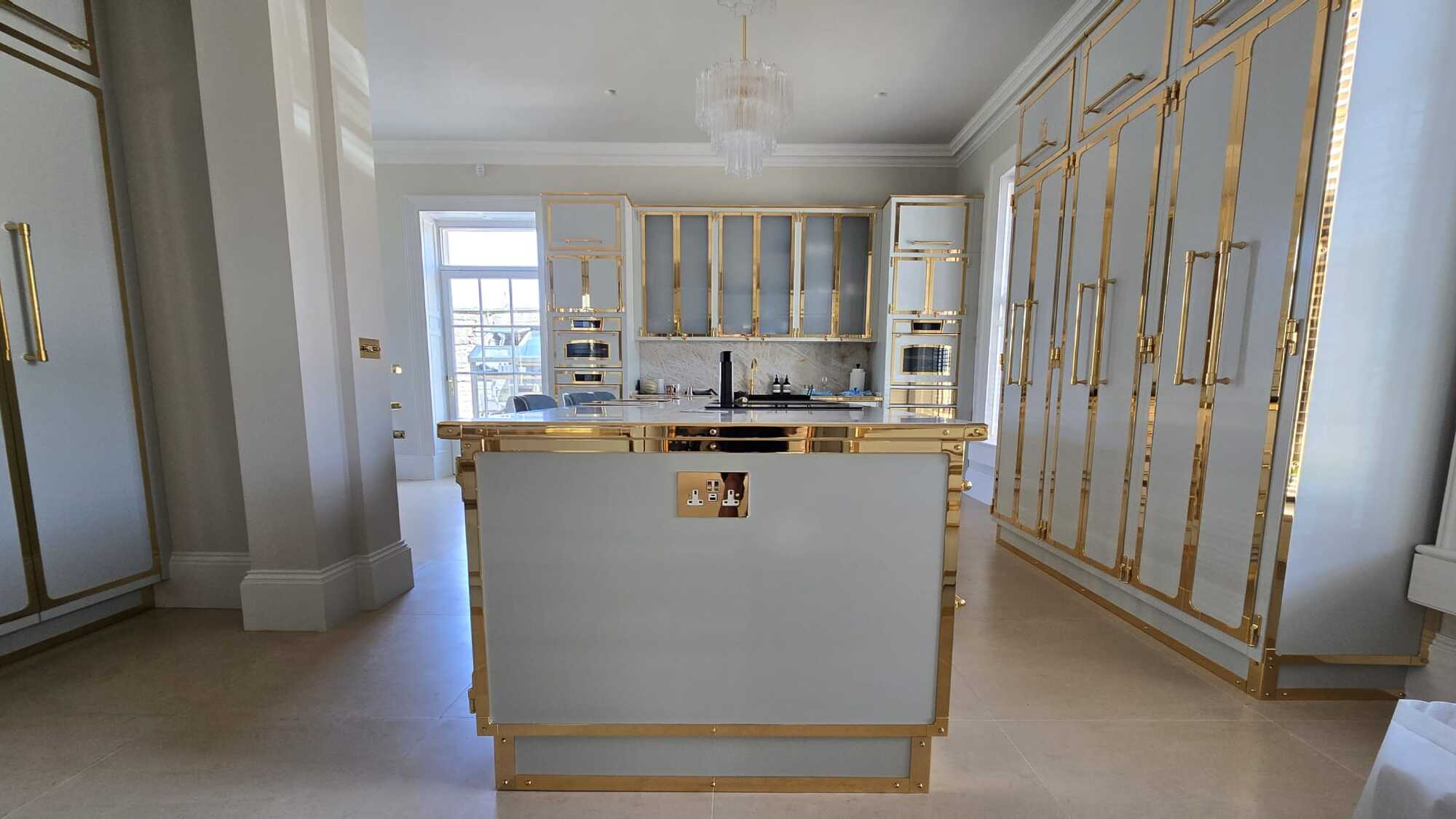 Brass-framed kitchen in a Cotswolds country house with invisible whole-house audio overhead
