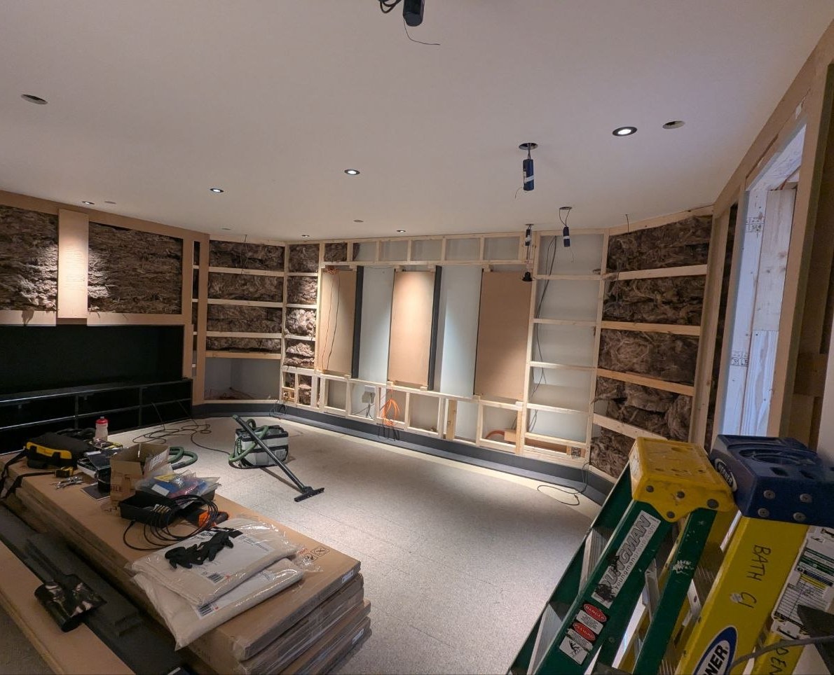 Room during first fix with open stud walls, acoustic insulation and cabling in place