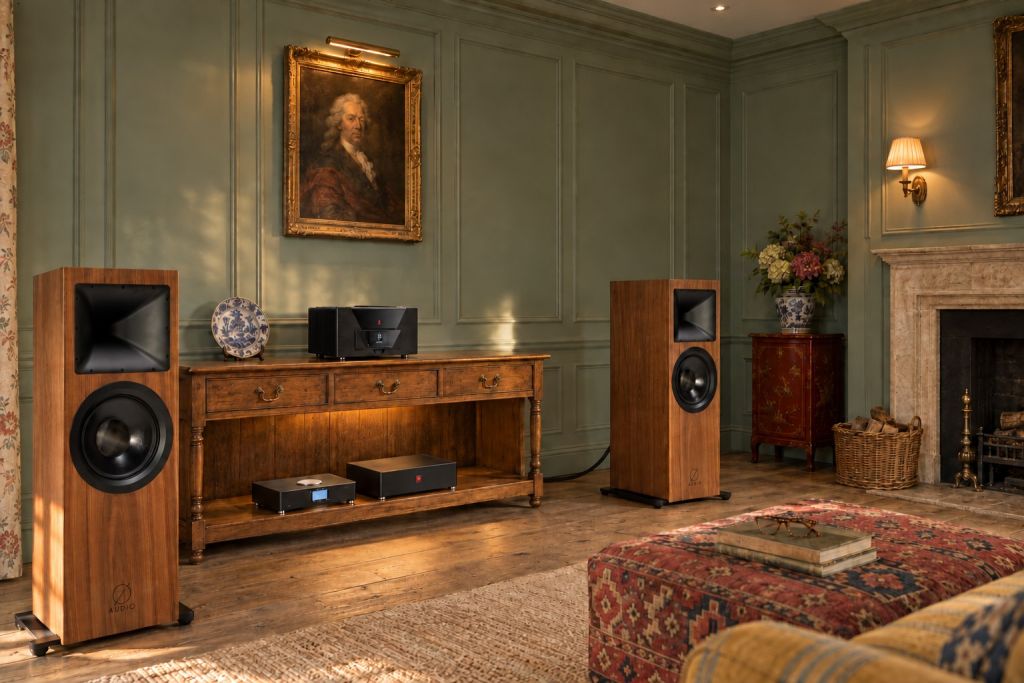 Illustration of two Ø Audio Icon 12 loudspeakers either side of an oak dresser base carrying a Gryphon Diablo 333 amplifier, with a Grimm MU2 and a Gryphon PowerZone 3 on its pot-board, in a sea-green panelled room with an 18th-century portrait, a stone chimneypiece and a red lacquer cabinet.